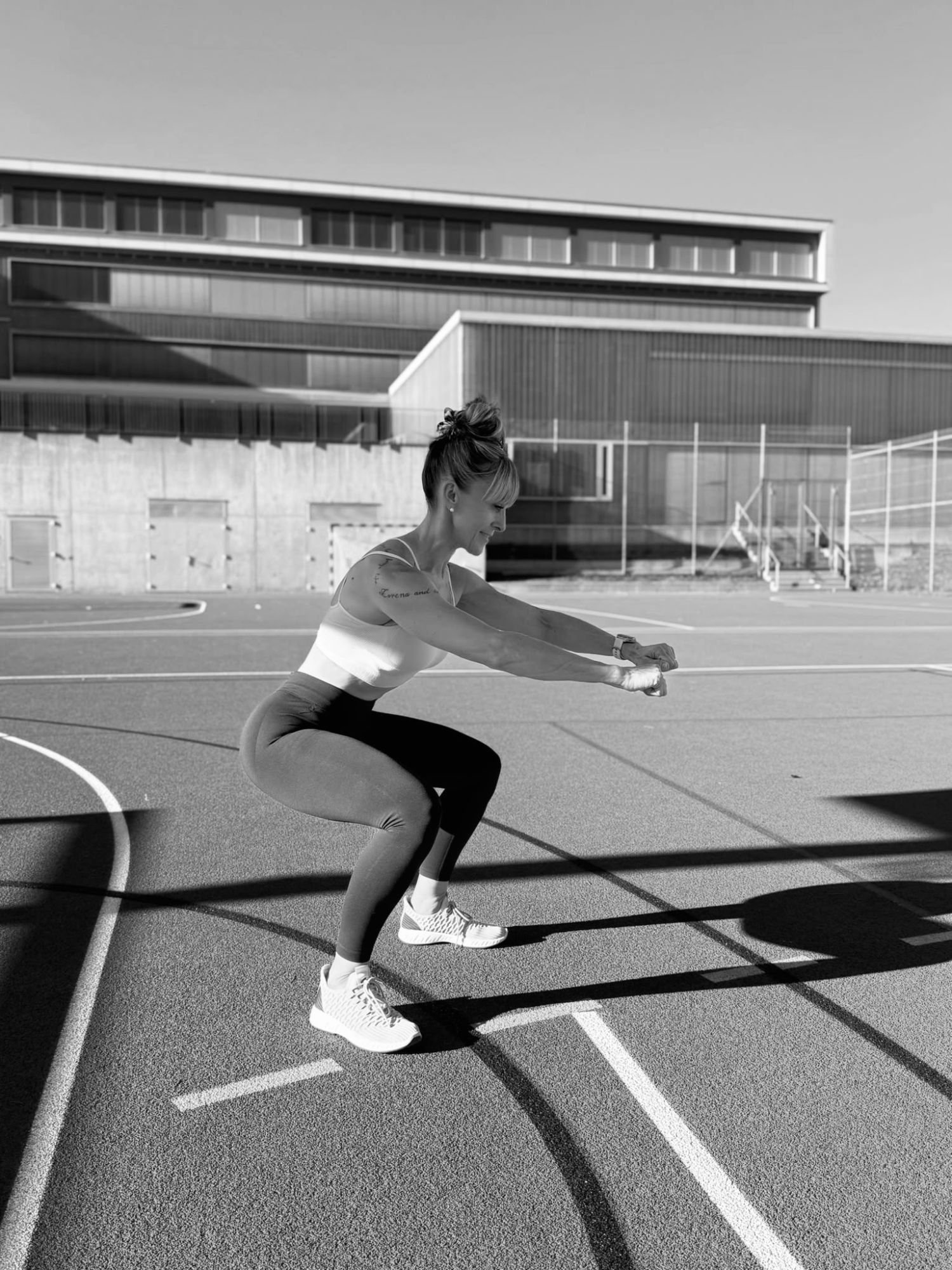 Vesna beim Kniebeugen-Training draussen auf einem Sportplatz